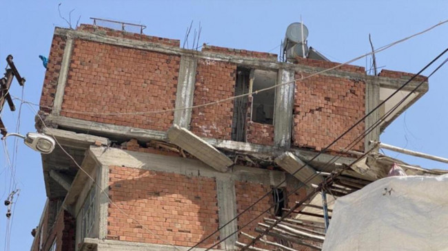 Depremin yıktığı binada ilginç görüntüler… Ara kat yıkıldı, en üst kat döndü